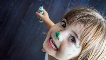 Lachendes Mädchen mit Stift in der Hand.