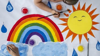 Kinder malen Regenbogen.