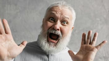 Lachender Opa, der die Hände in die Luft hebt.