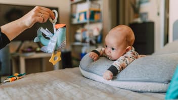 Ein Baby, das mit einem Vogel spielt