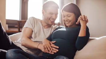 Paar streichelt den Babybauch.