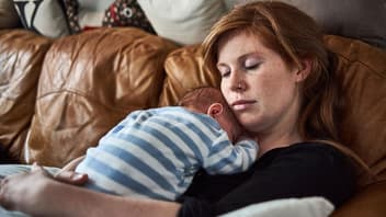 Mama schläft mit Baby auf ihrem Bauch.