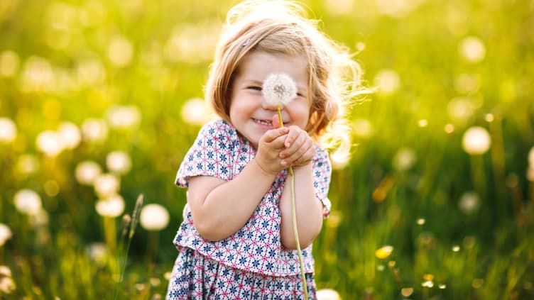 Mädchen hält eine Pusteblume in der Hand