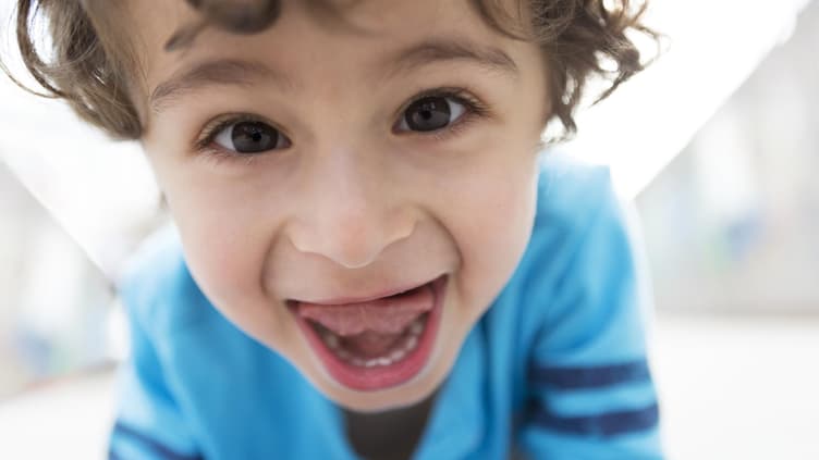 Kind streckt Zunge raus.