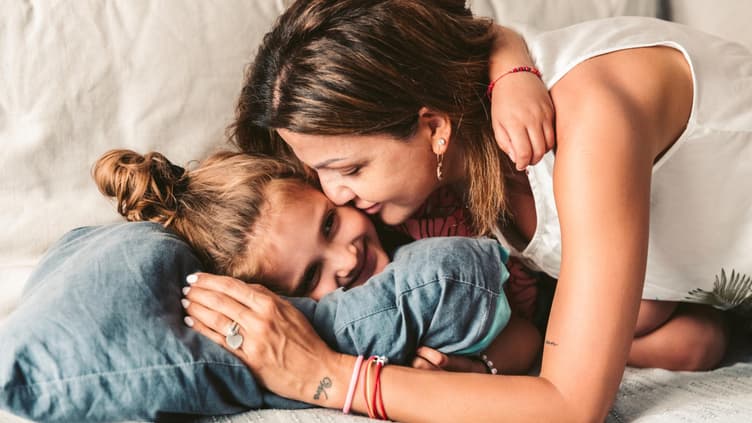 Eine Mutter kuschelt mit ihrer Tochter.