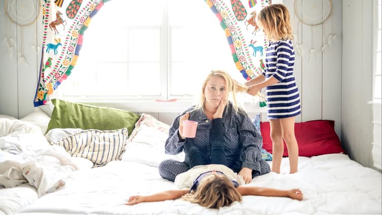 Mutter mit ihren zwei Kindern im Bett