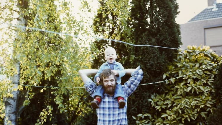 Junger Vater in den achtziger Jahren mit seinem Sohn.