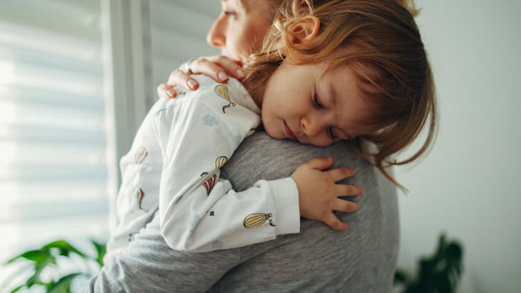 Kind kuschelt mit seiner Mutter.