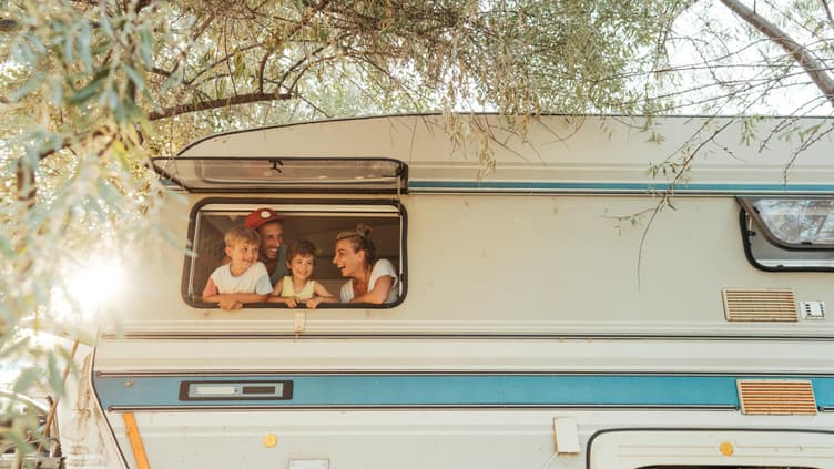 Familie schaut aus Wohnmobil-Fenster