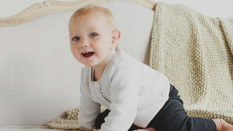Kleines Mädchen sitzt auf Sofa.