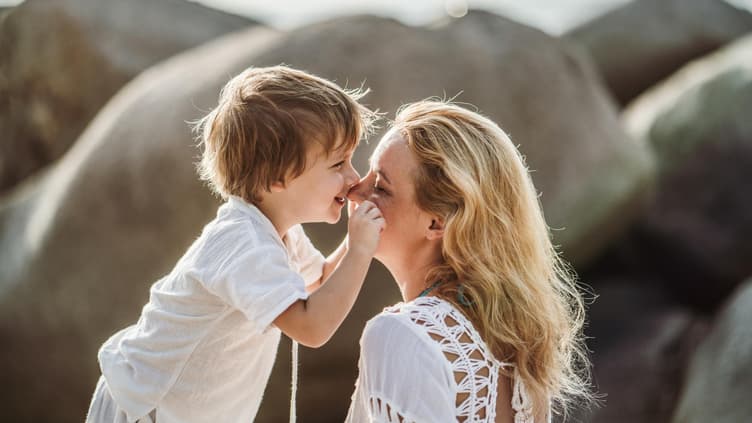 Ein kleiner Junge gibt seiner Mama ein Küsschen.