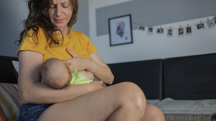 Mutter legt ihr Baby zum Stillen an. 