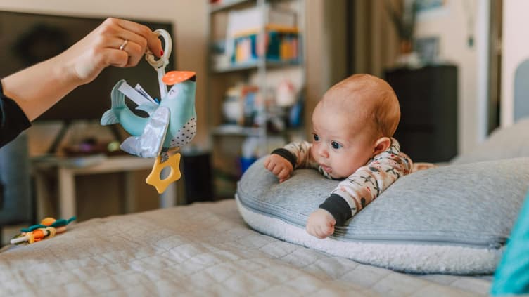 Ein Baby, das mit einem Vogel spielt