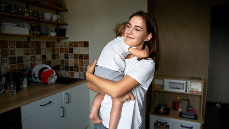 Mama und Kleinkind umarmen sich.