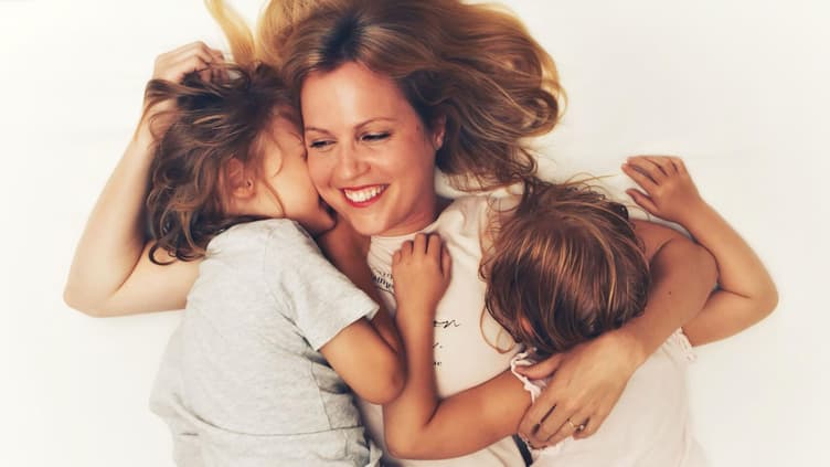 Mutter im Bett mit zwei Kindern.