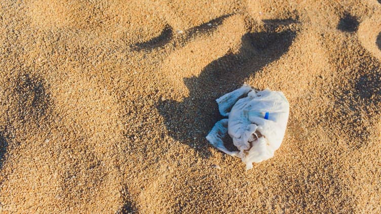 Eine dreckige Windel liegt am Strand