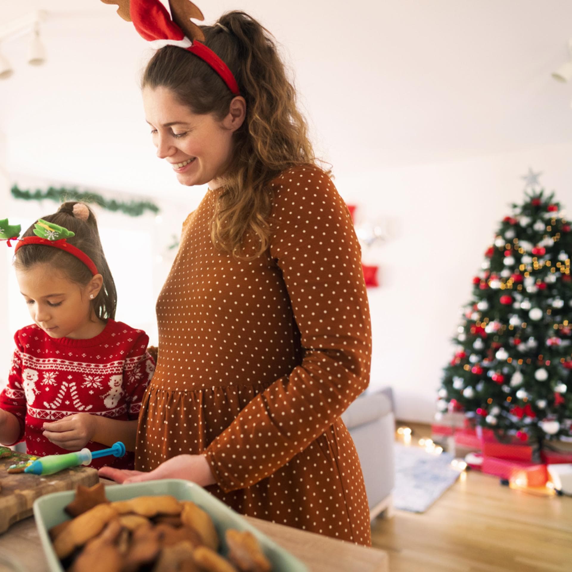 Mutter und Kind backen Weihnachtskekse.