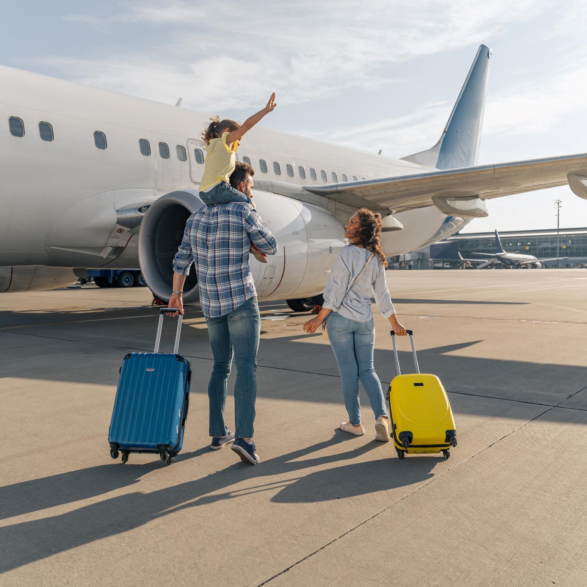 Familie mit schulpflichtigem Kind am Flughafen.