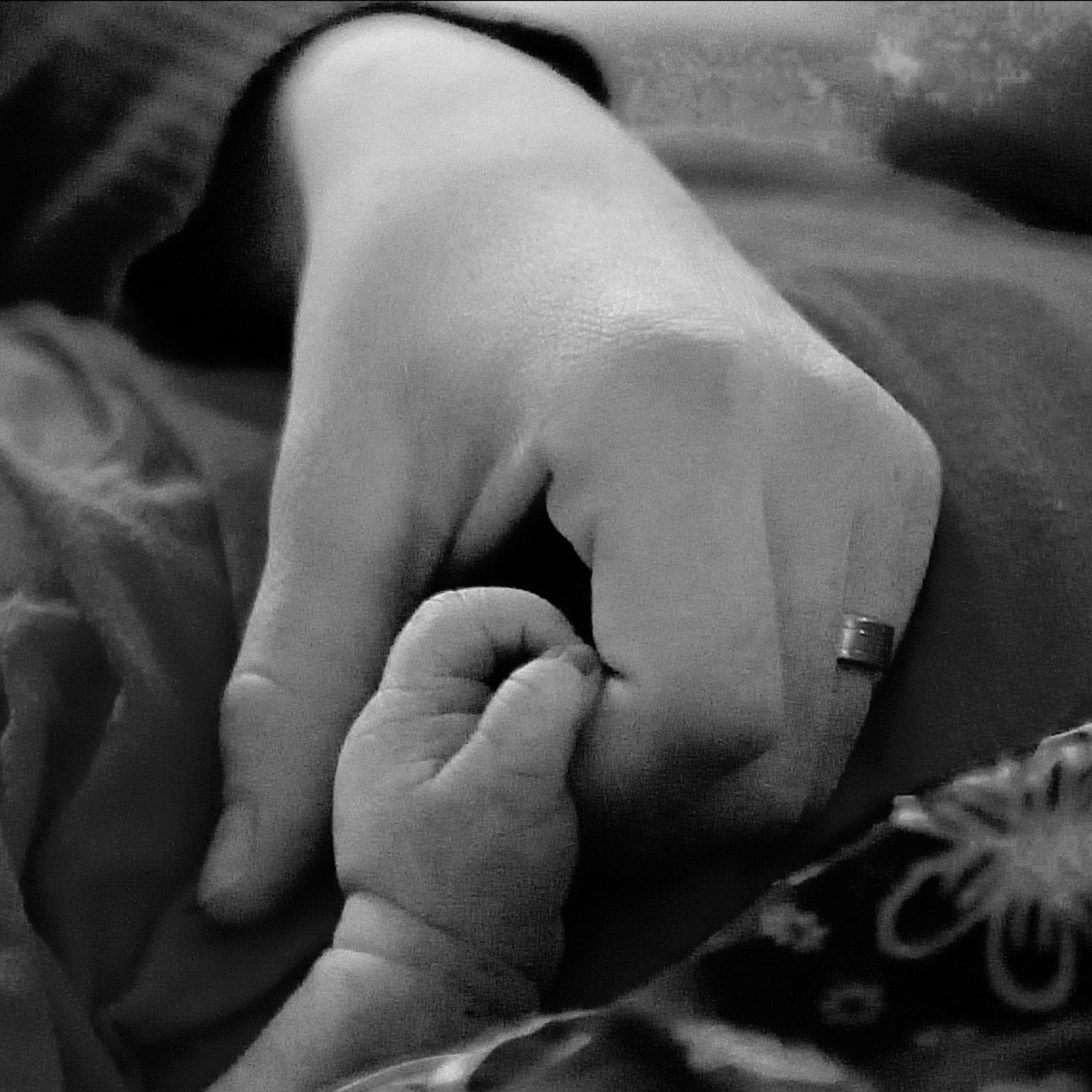 Frau hält Hand ihres Babys