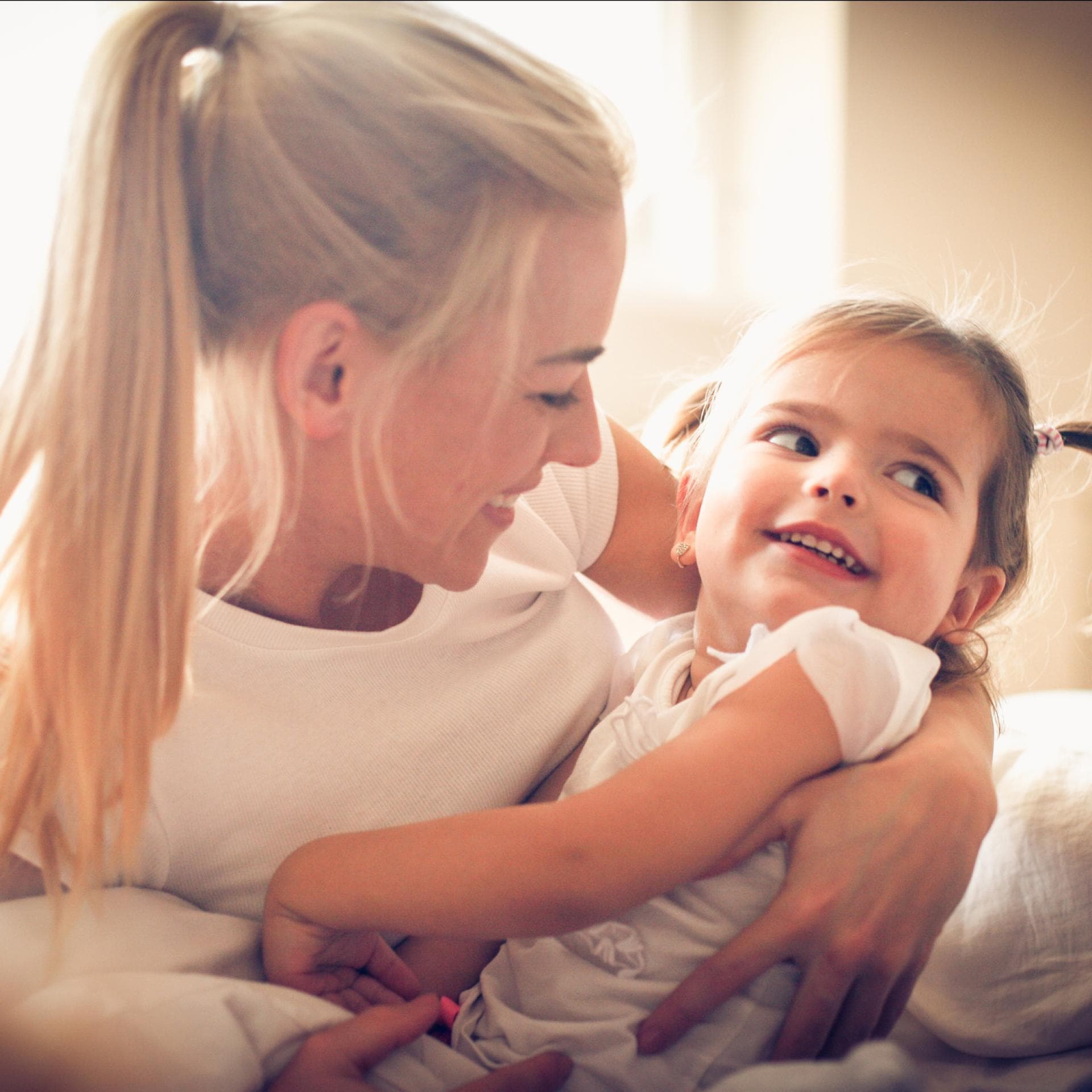 Mutter umarmt ihre kleine Tochter