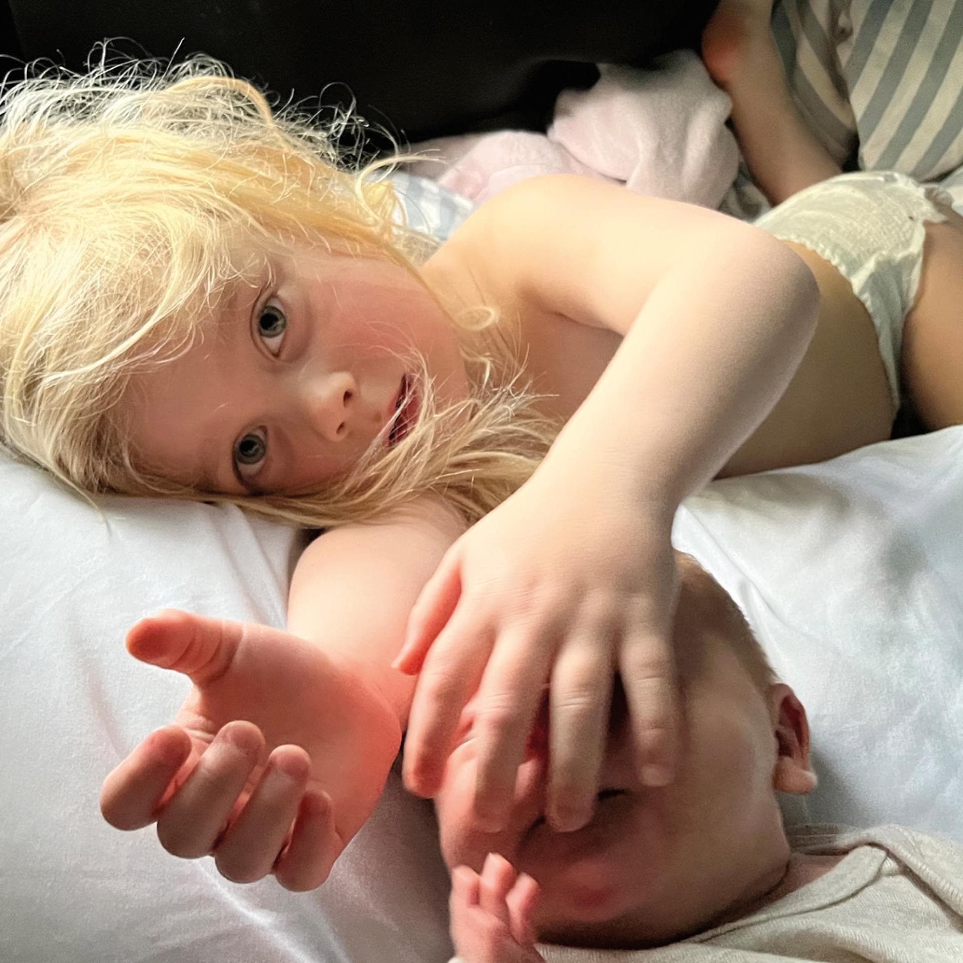 Zwei Geschwister liegen zusammen im Bett