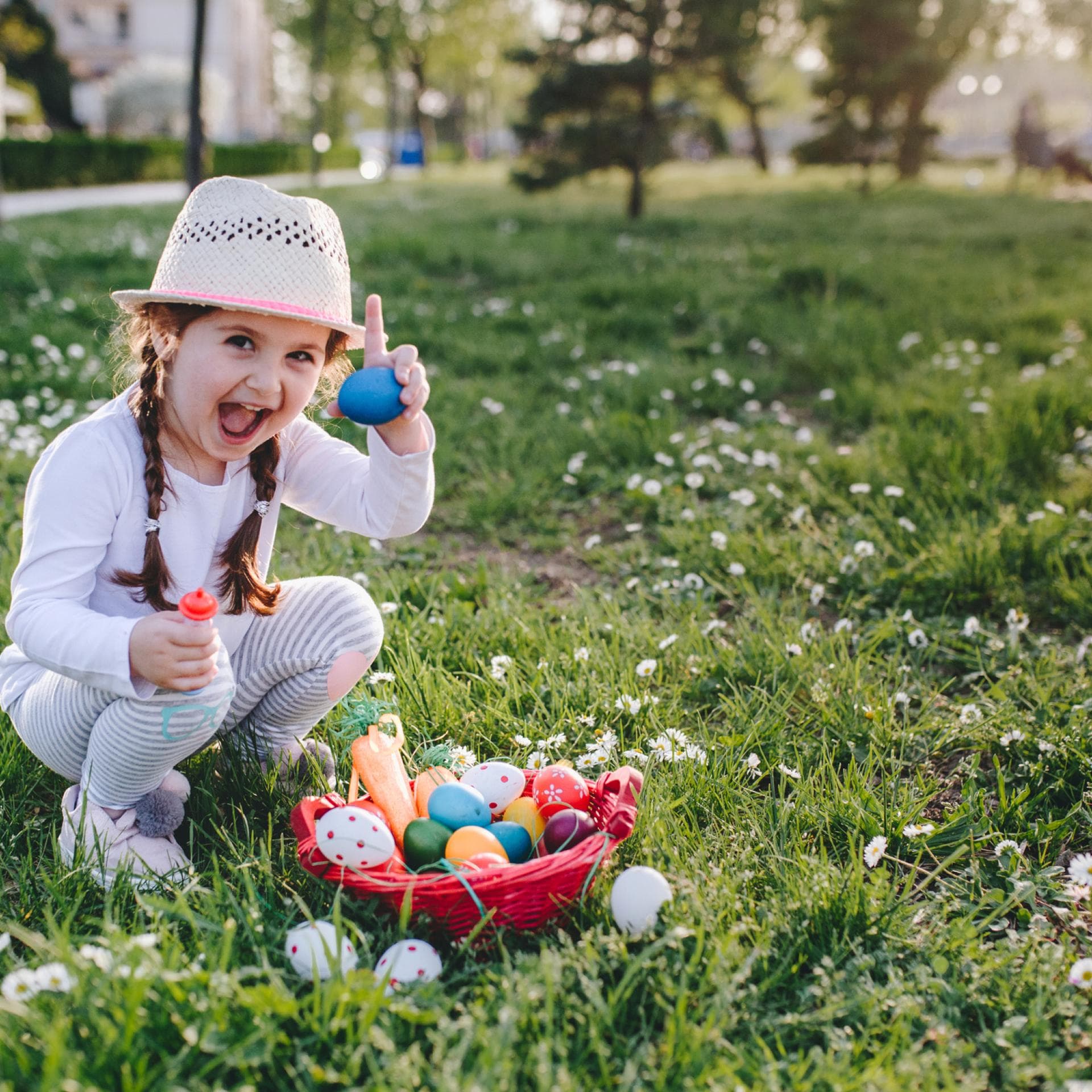 Ein Mädchen zeigt stolz sein Osternest