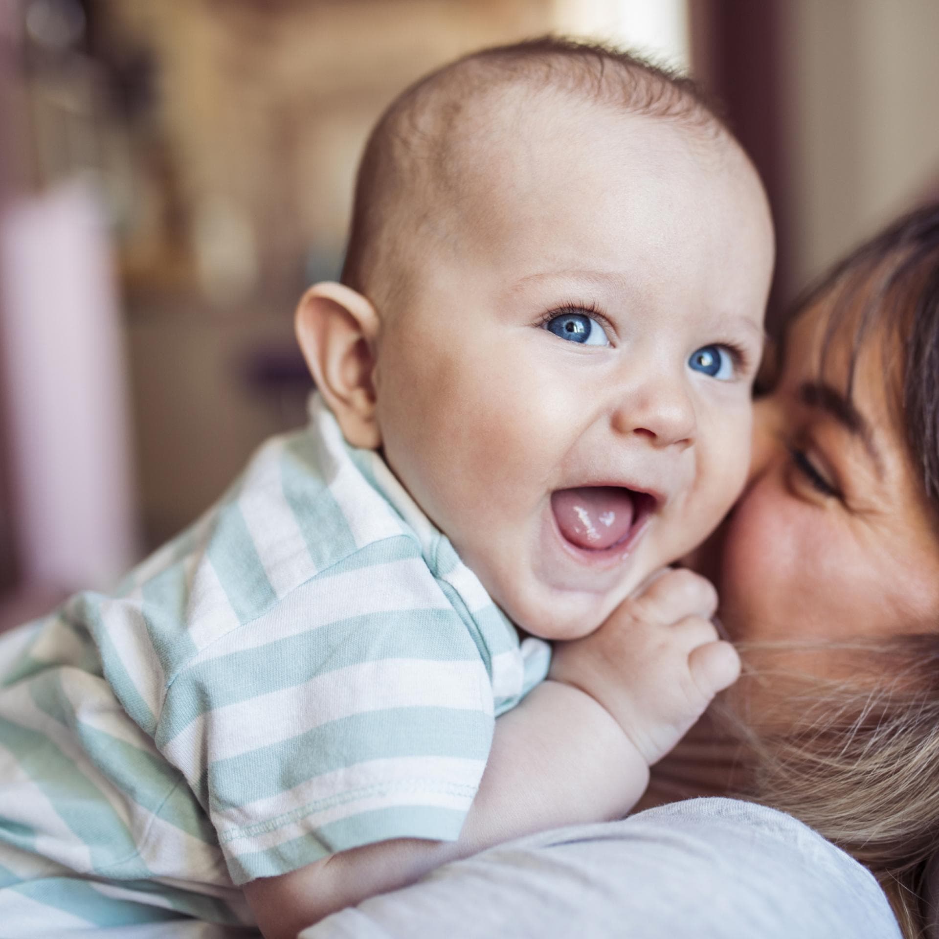 Mama küsst ihr lachendes Baby