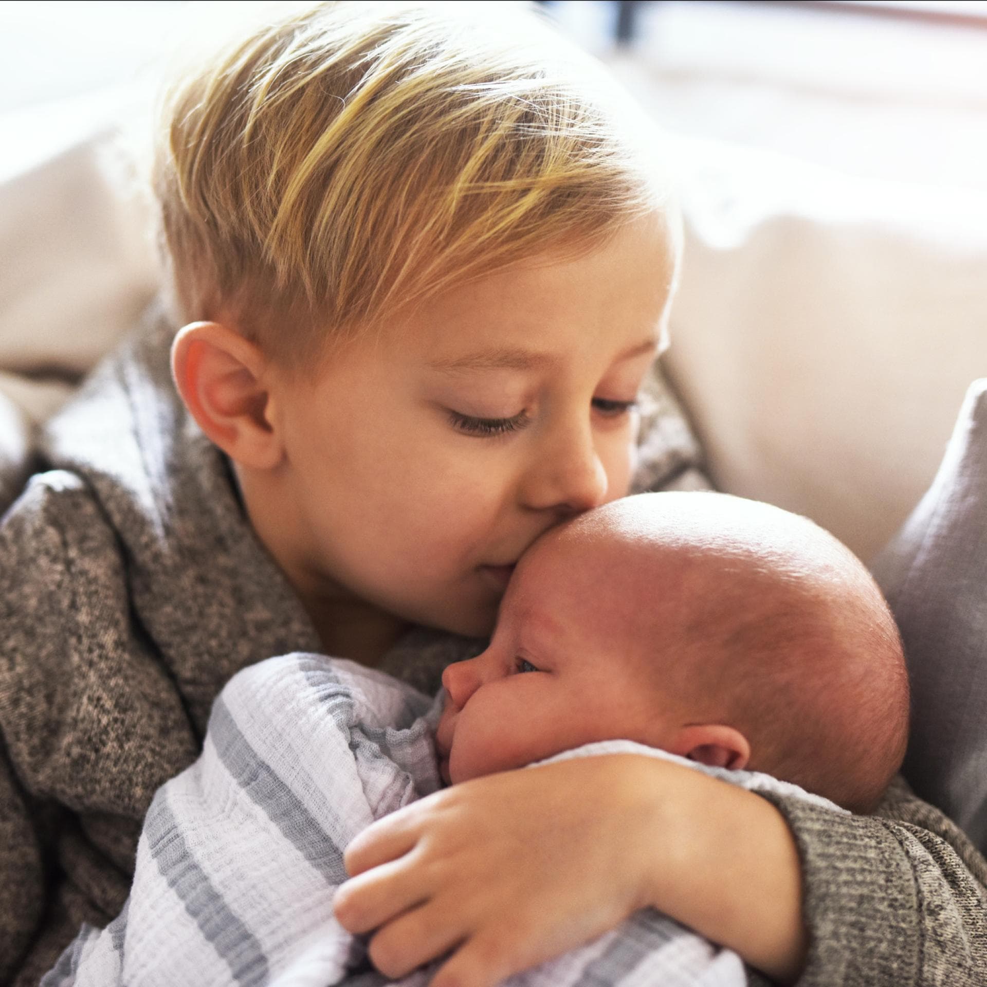 Großer Bruder küsst kleinen Bruder. 