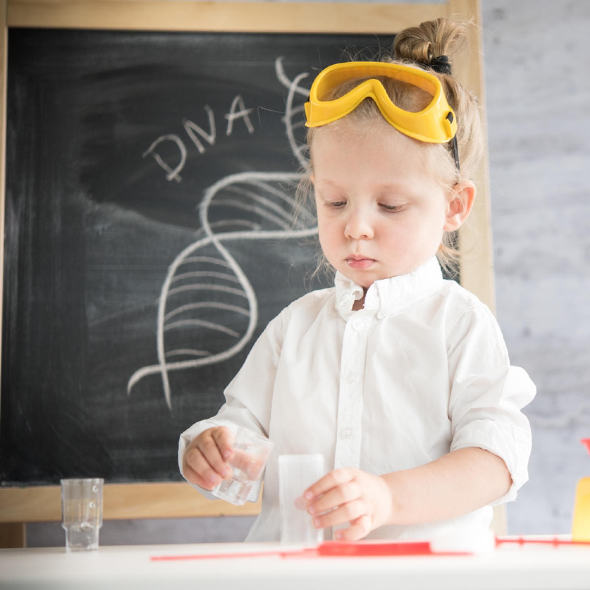 Kleines Mädchen experimentiert im Kinder-Chemie-Labor