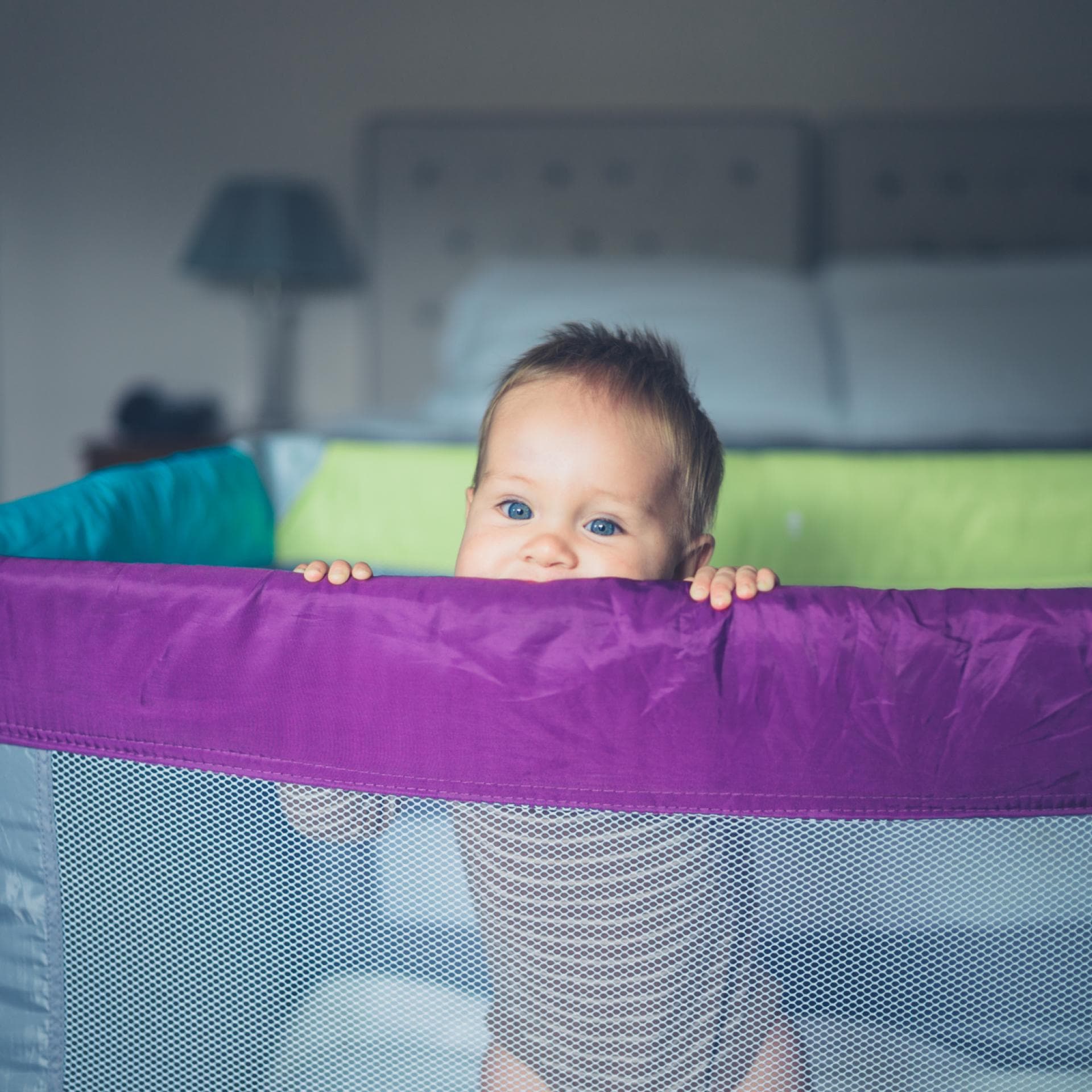 Baby schaut aus Reisebett