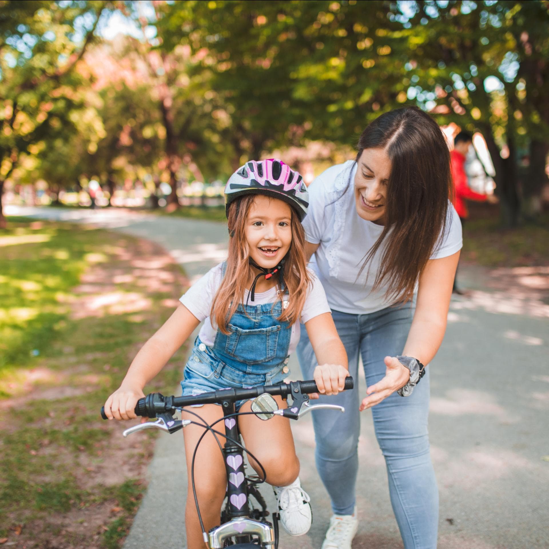 Mama bringt Tochter Fahrradfahren bei
