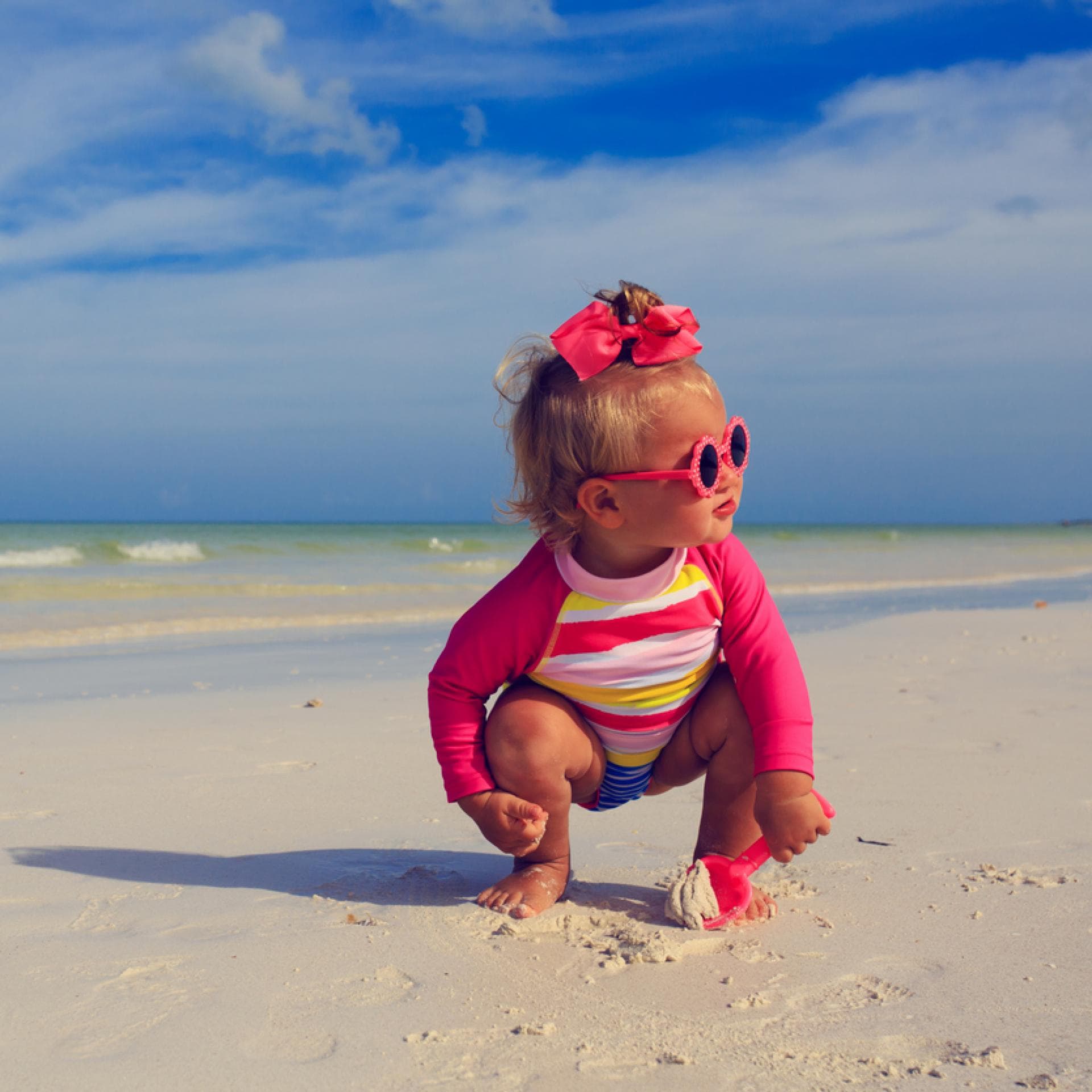 Ein kleines Mädchen spielt am Strand.