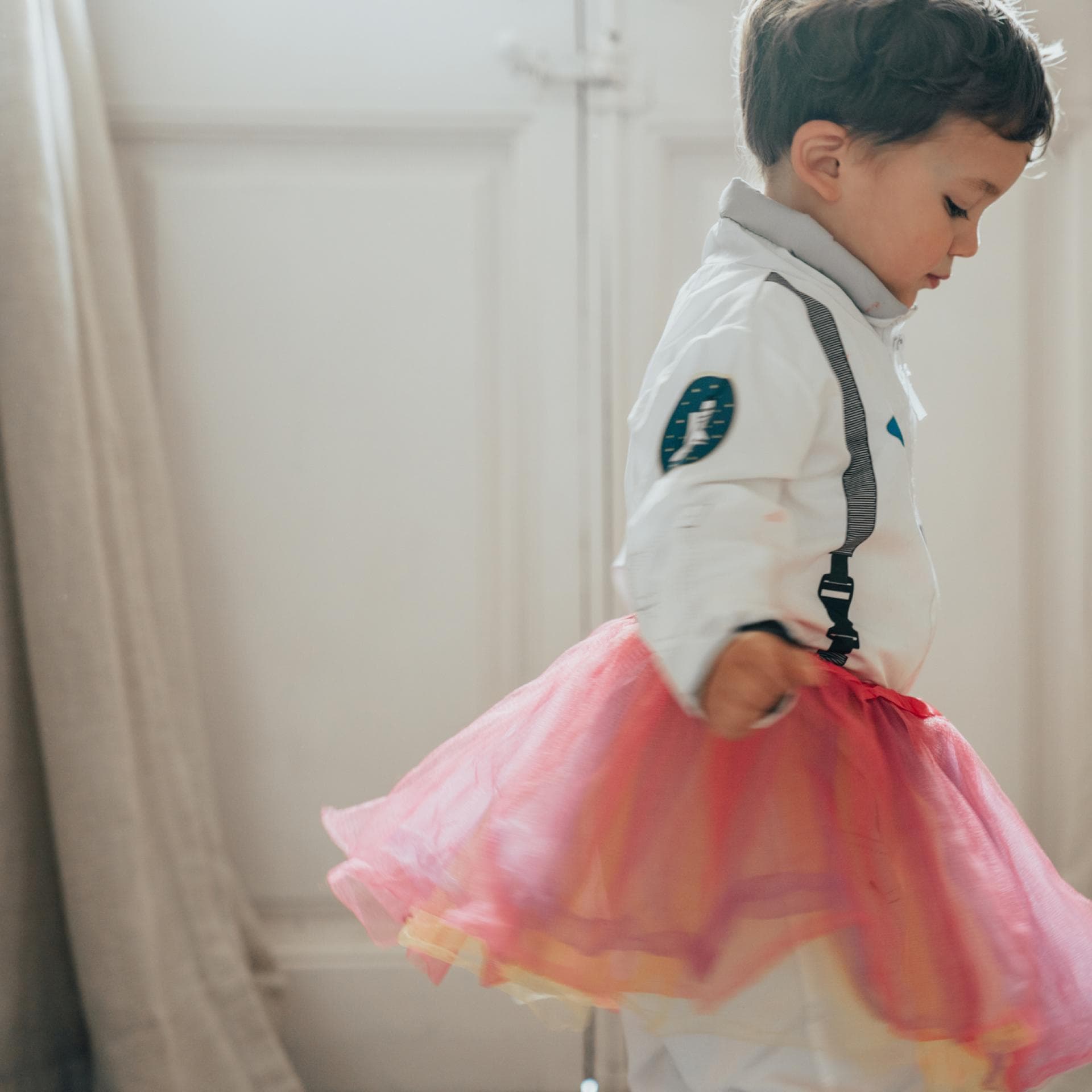 Junge trägt einen rosa Rock.