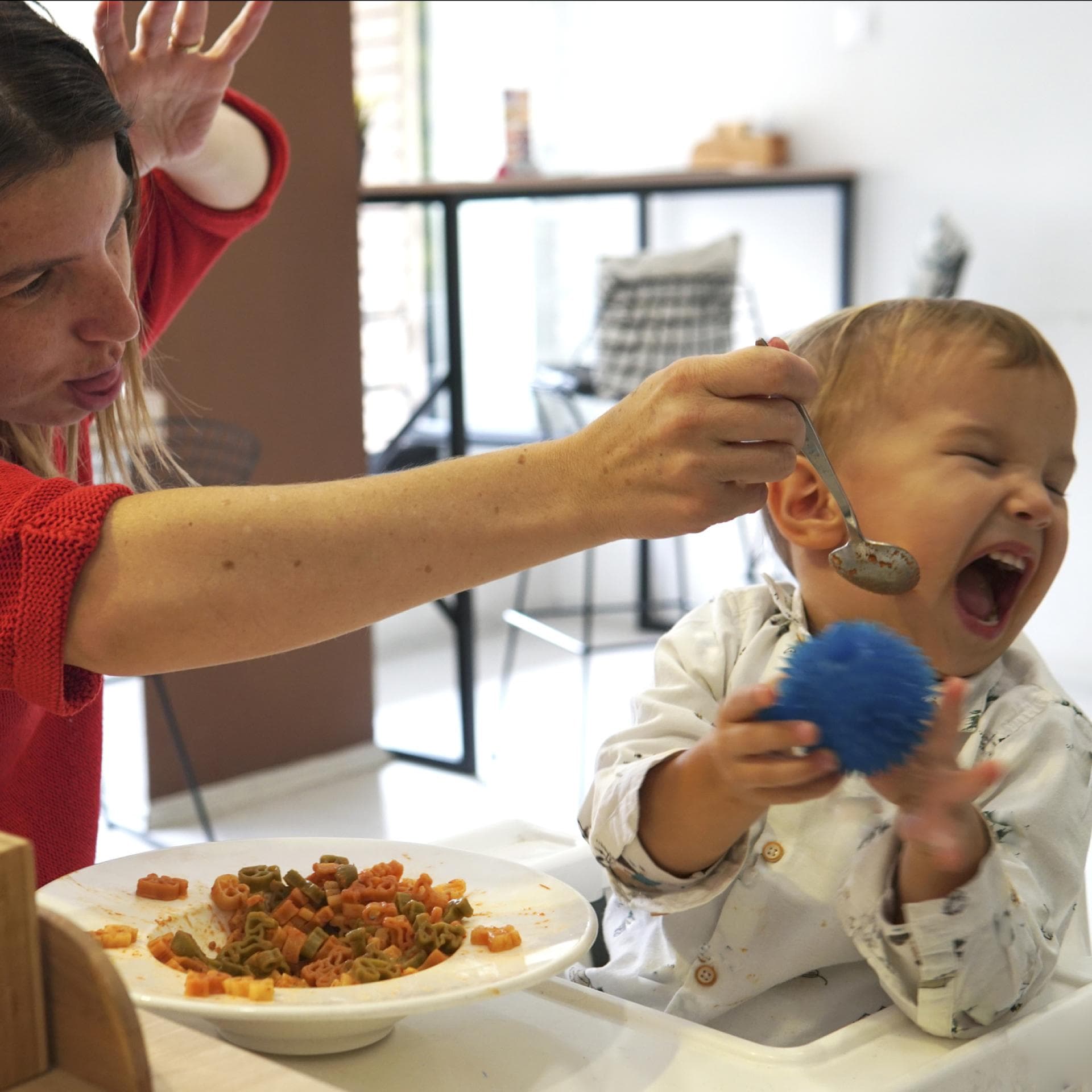 Eine Mutter versucht vergeblich ihr Kleinkind zu füttern.