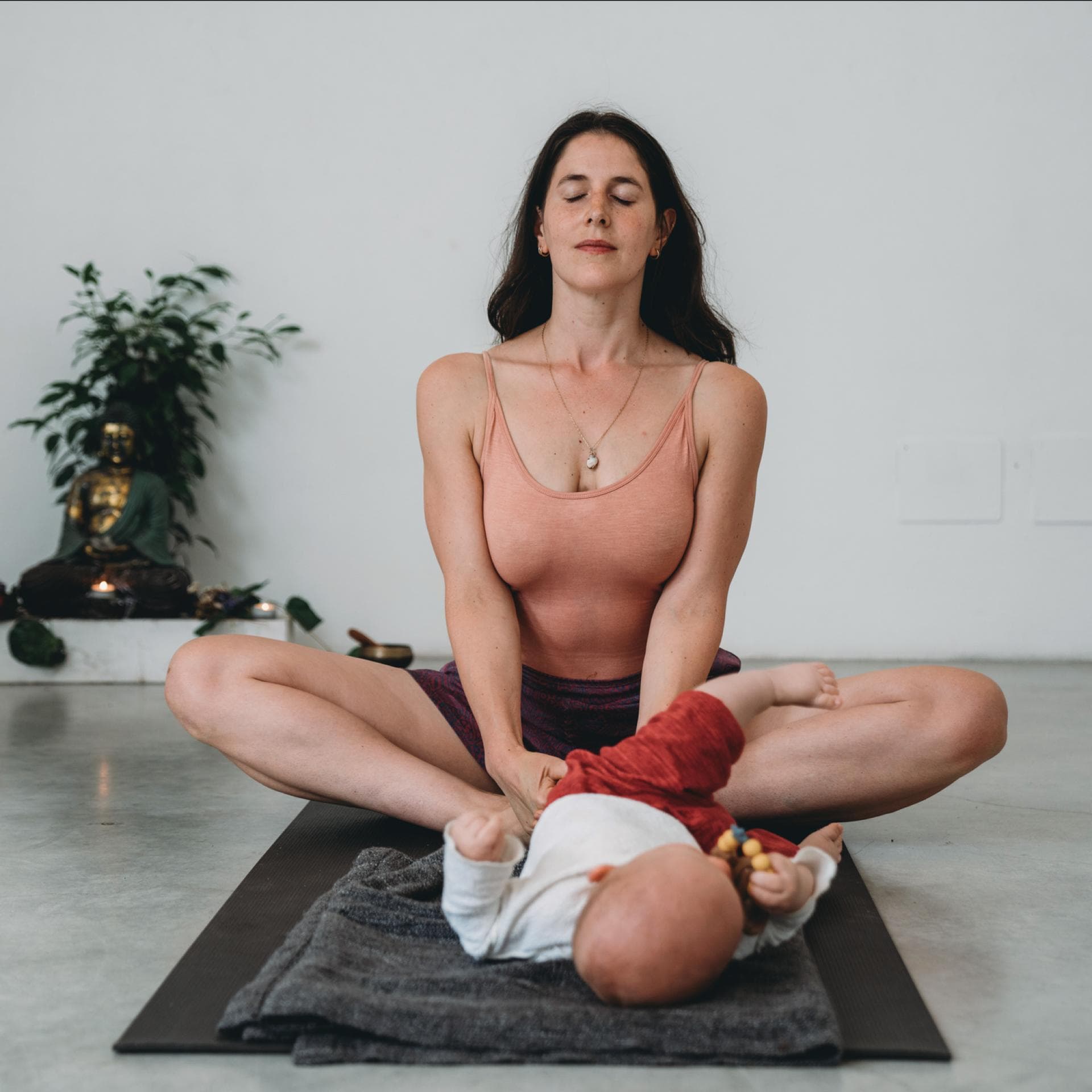 Frau beim Yoga mit Baby.