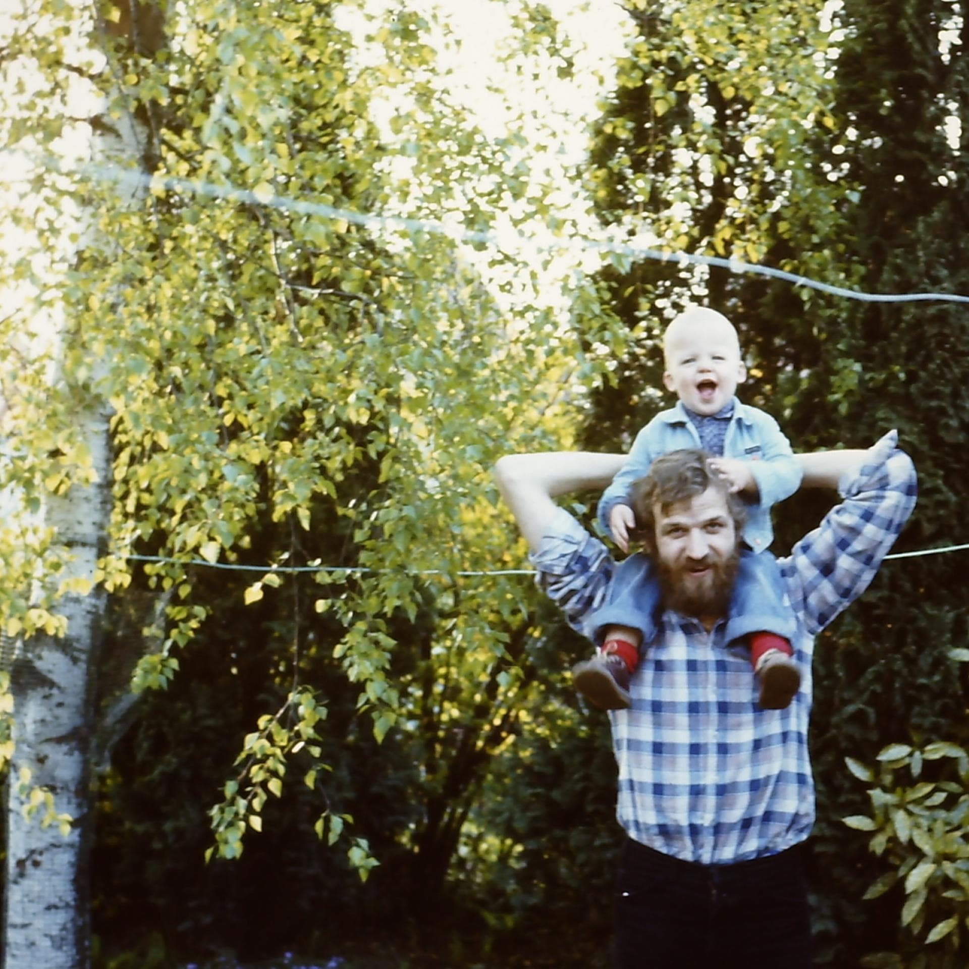 Junger Vater in den achtziger Jahren mit seinem Sohn.
