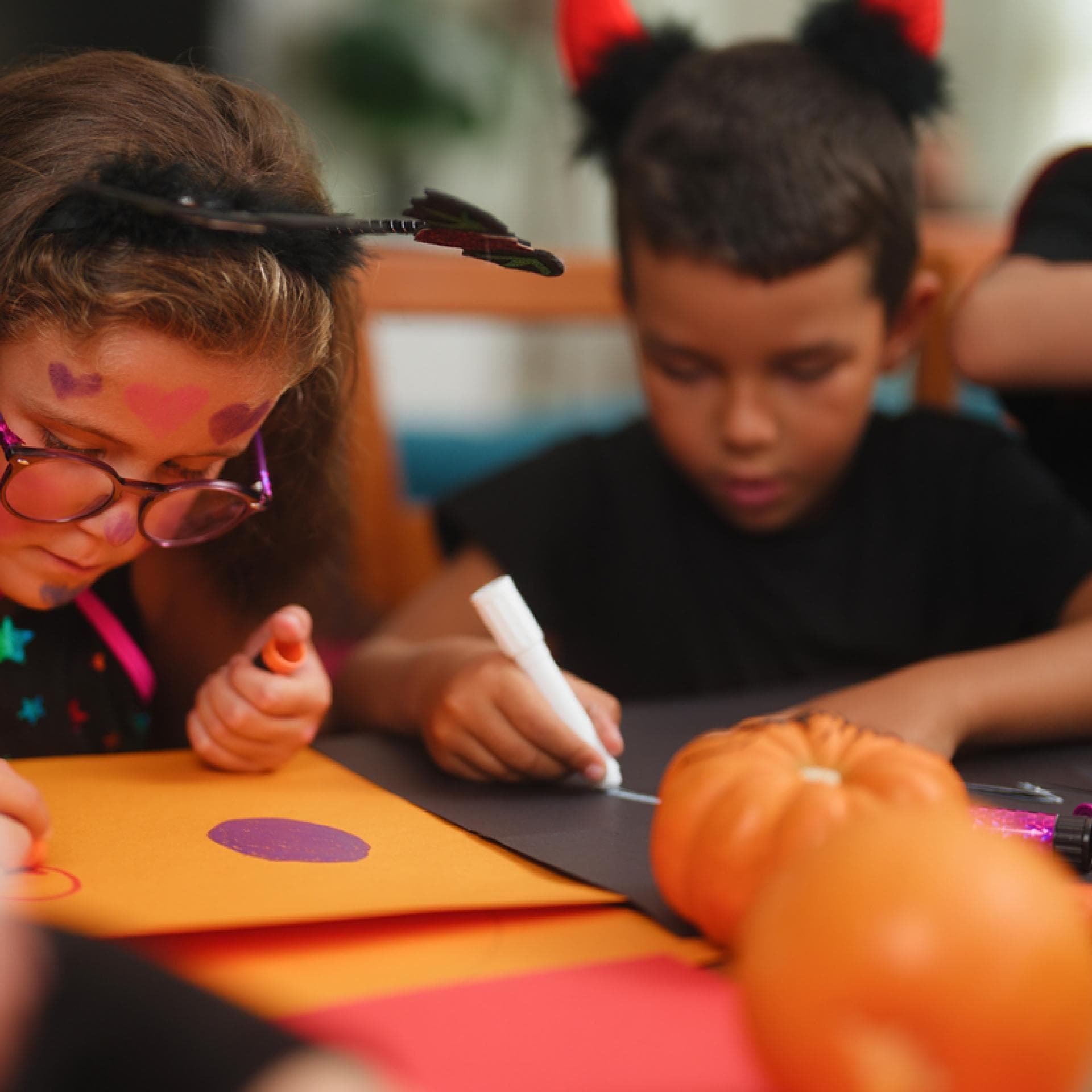 Kinder basteln zusammen eine Fledermaus-Laterne.