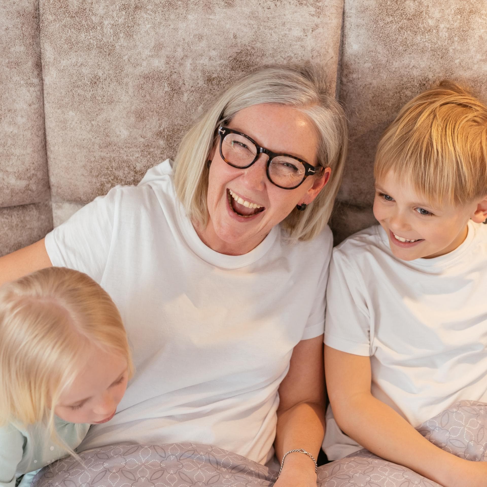 Oma lacht mit ihren beiden Enkeln.