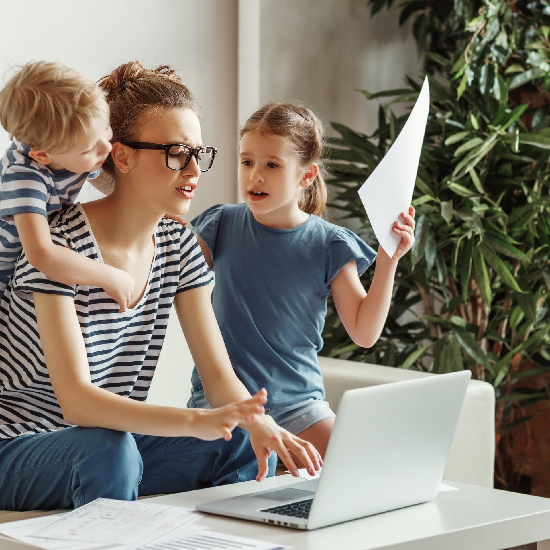 Frau am Laptop mit zwei Kindern.