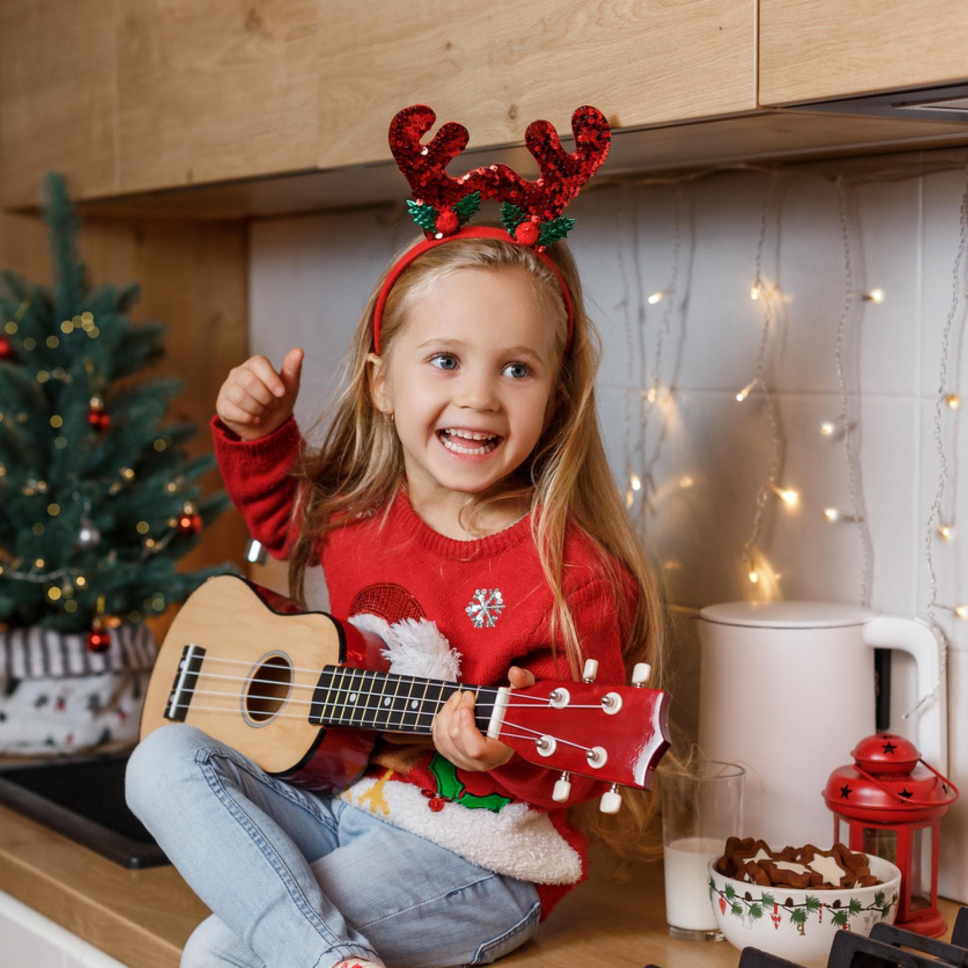 Kleines Mädchen singt mit Gitarre in der Hand ein Nikolauslied.