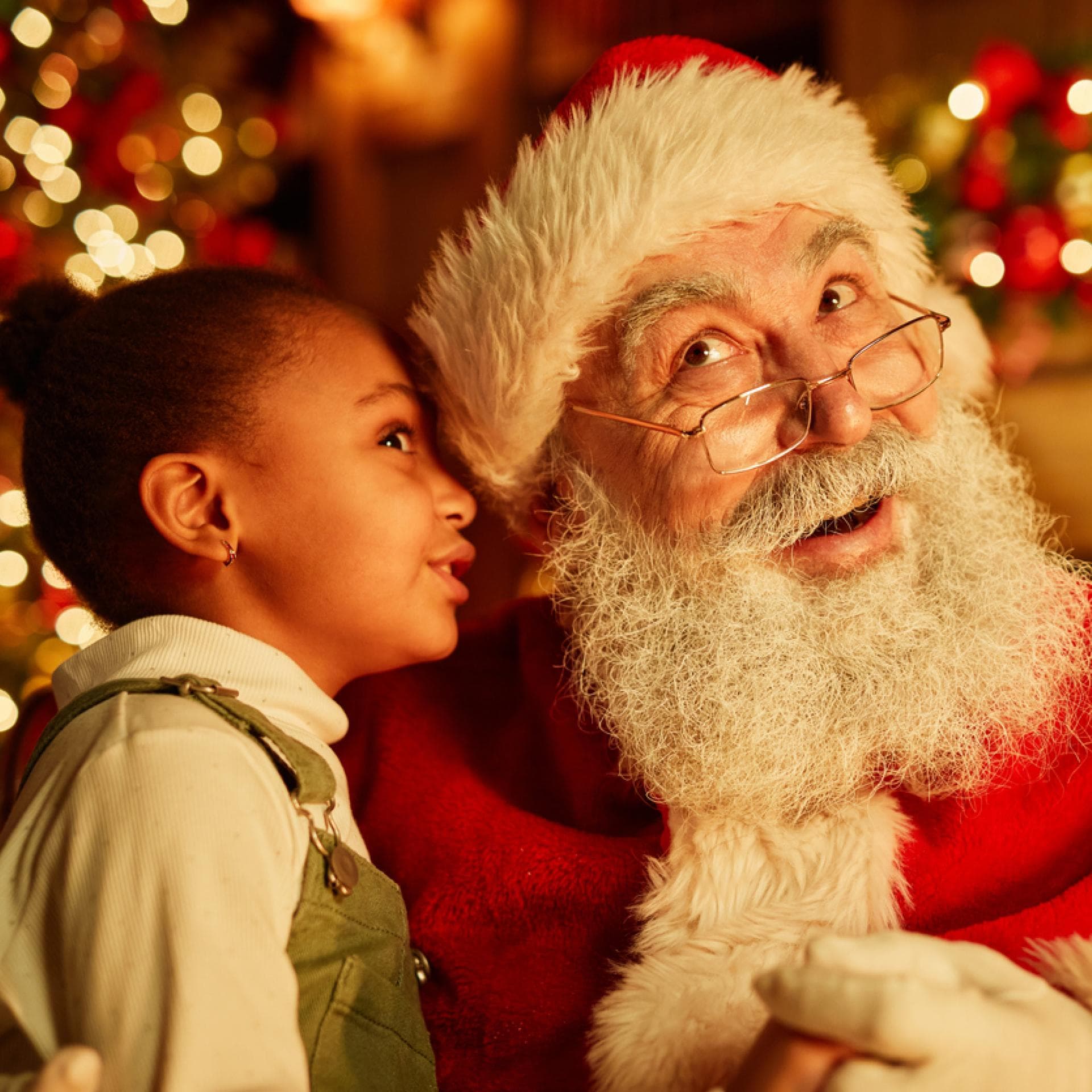 Kleines Mädchen flüstert dem Nikolaus ein Gedicht ins Ohr.