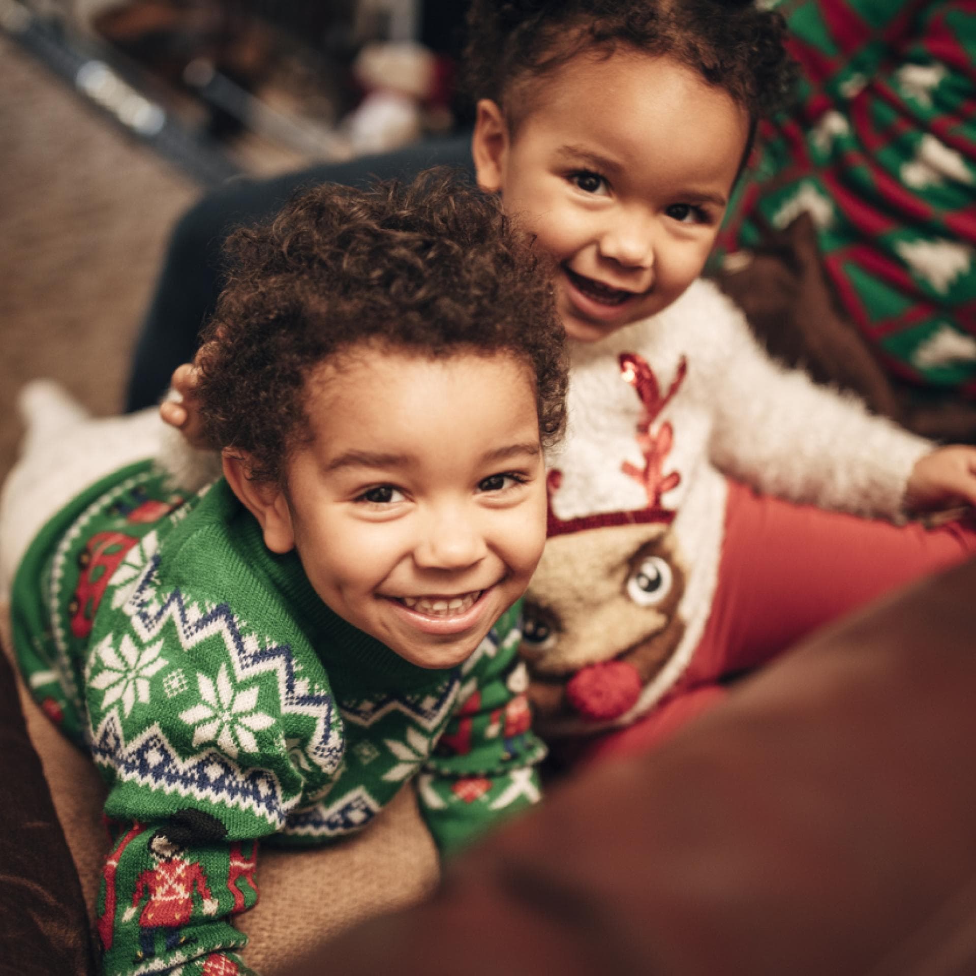 Zwei kleine Kinder in süßen Wiehnachtspullovern.