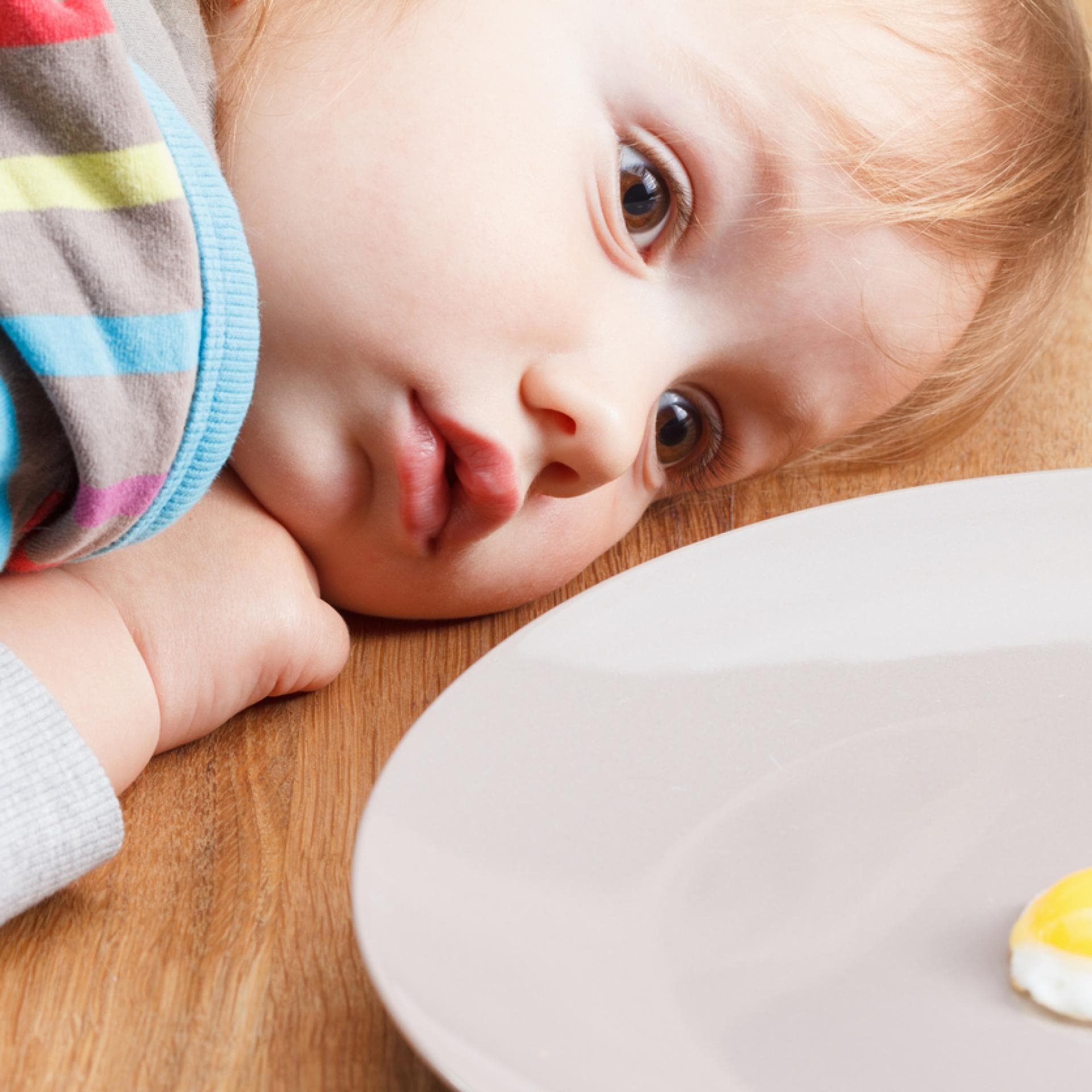 Baby schaut sich ein Spiegelei genau an. 