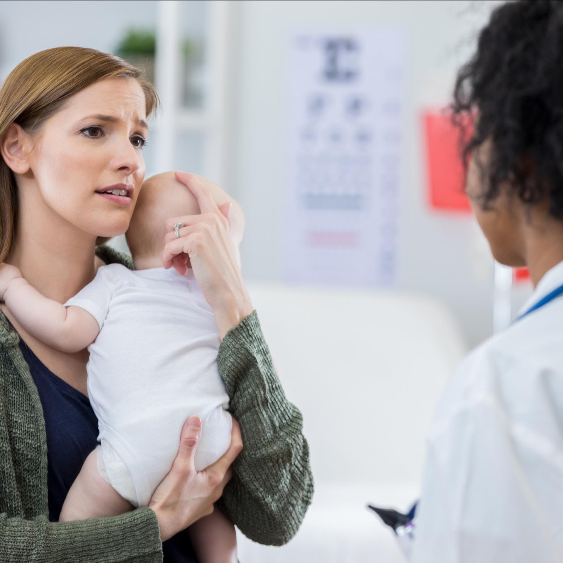 Eine Mutter steht mit ihrem Baby auf dem Arm in der Notfallambulanz.