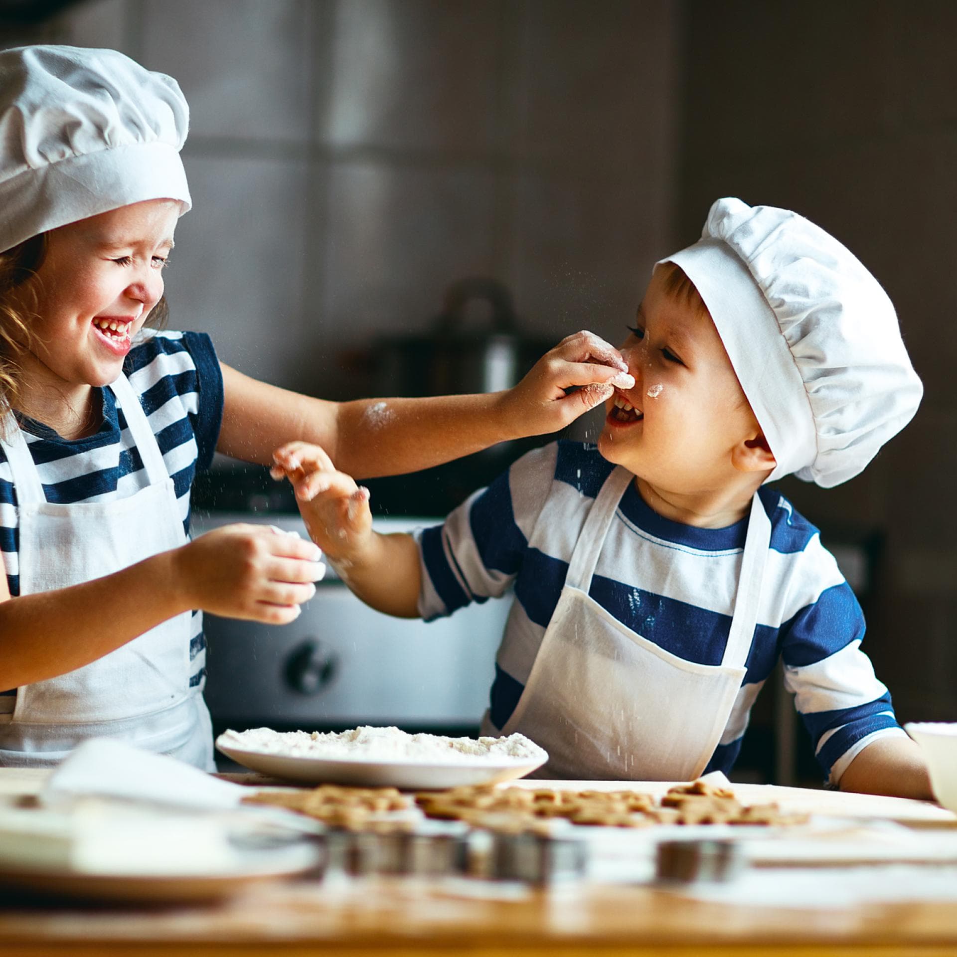 Zwei kleine, niedliche Kinder backen Kekse.