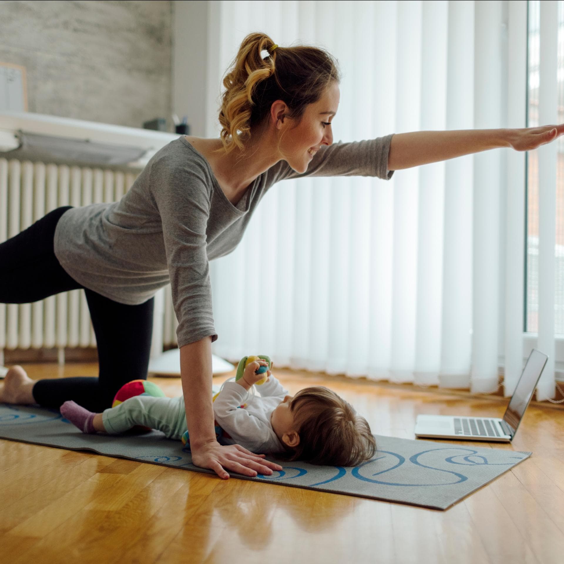 Eine Mama macht nach der Geburt Beckenbodentraining mit ihrem Baby. 
