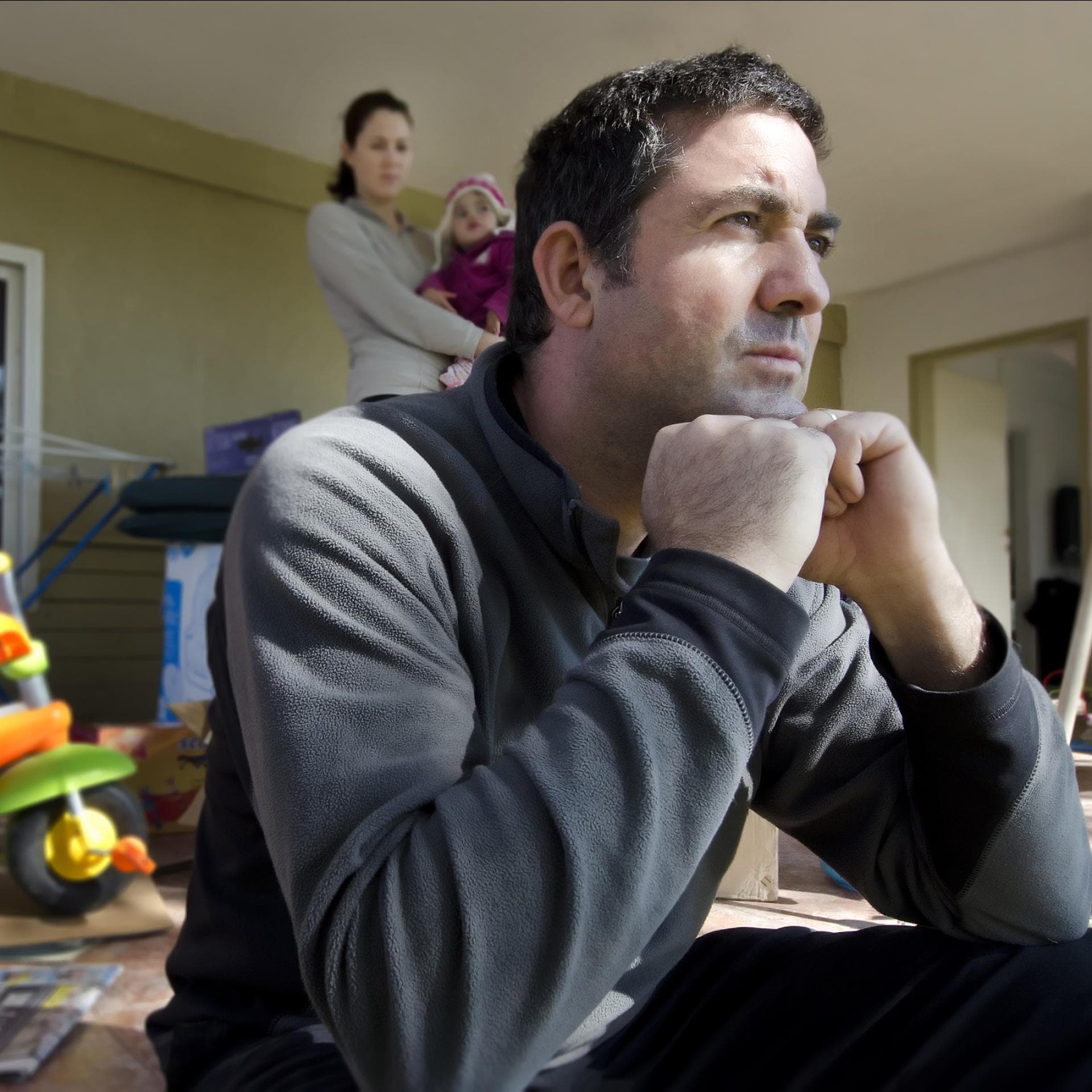 Eine Mutter mit Baby auf dem Arm streitet sich mit ihrem Mann.