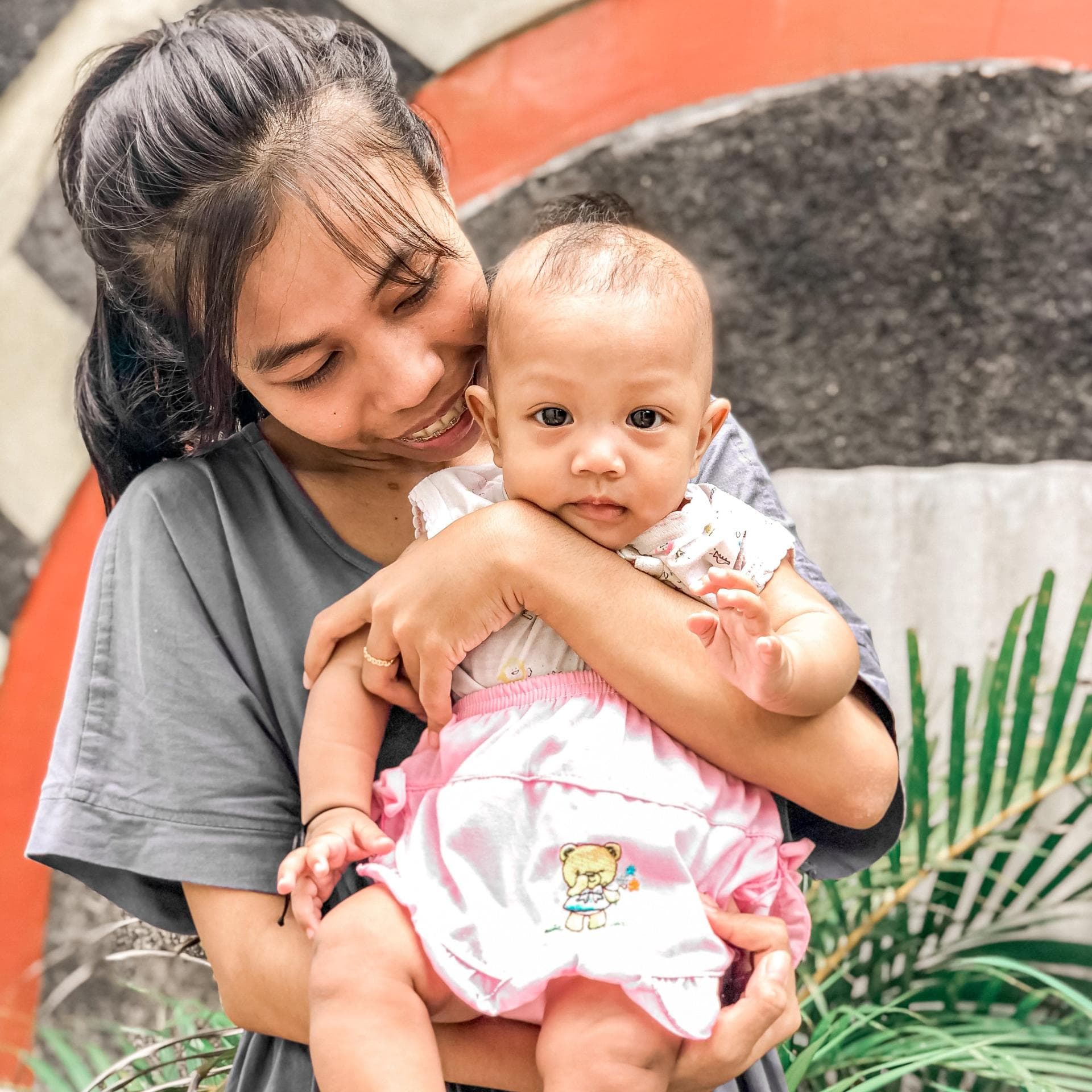 Junge Frau mit Baby auf dem Arm.