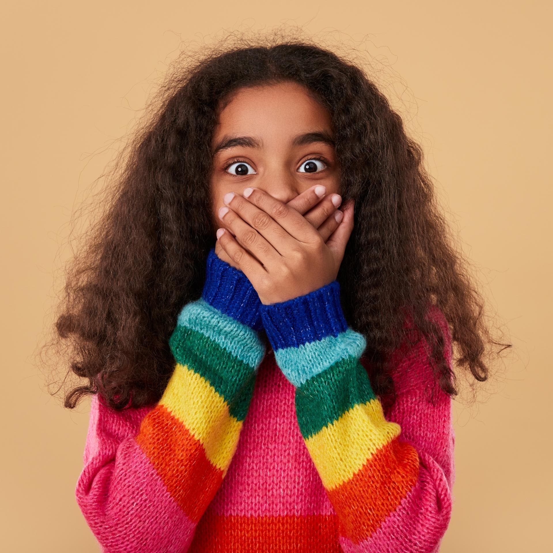 Erstauntes Mädchen hält sich die Hände vor den Mund