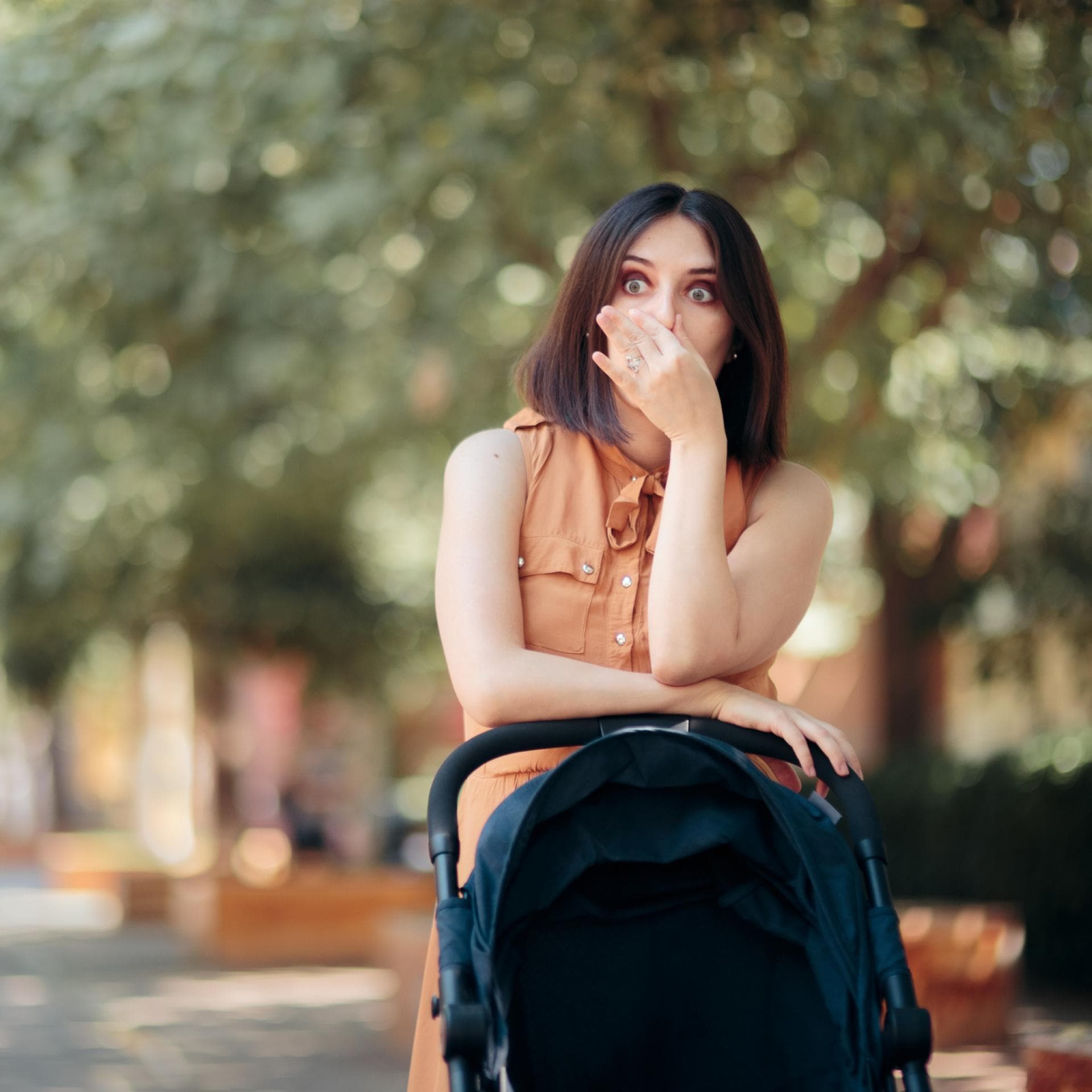 Mutter mit Buggy hält sich die Nase zu.